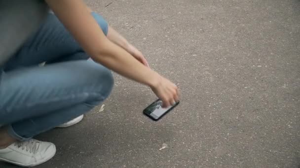 Woman pick up broken phone from floor — Stock Video