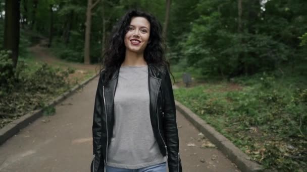 Jovem bela morena encaracolado feminino sorrindo e andando — Vídeo de Stock