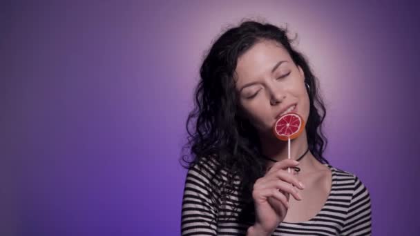 Studio shot de mujer de cabello oscuro con deliciosos dulces — Vídeo de stock