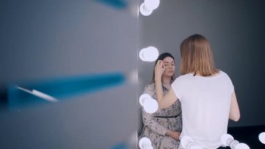 güzel kadın gözlerine gölgeler uygulayan sanatçı makyaj