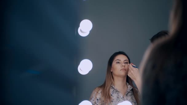 Make up artist tillämpa skuggor på ögonen på vackra kvinnliga — Stockvideo