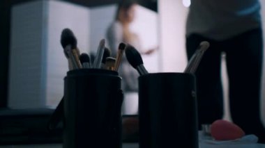 güzel kadın gözlerine gölgeler uygulayan sanatçı makyaj