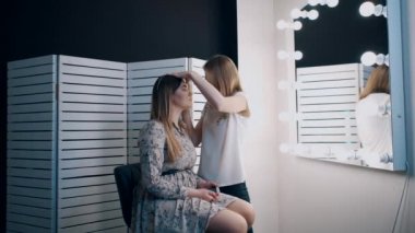 güzel kadın gözlerine gölgeler uygulayan sanatçı makyaj