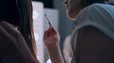 güzel kadın gözlerine gölgeler uygulayan sanatçı makyaj