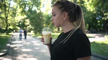 güneşli parkta karamel ile milkshake içme genç güzel örgülü kadın