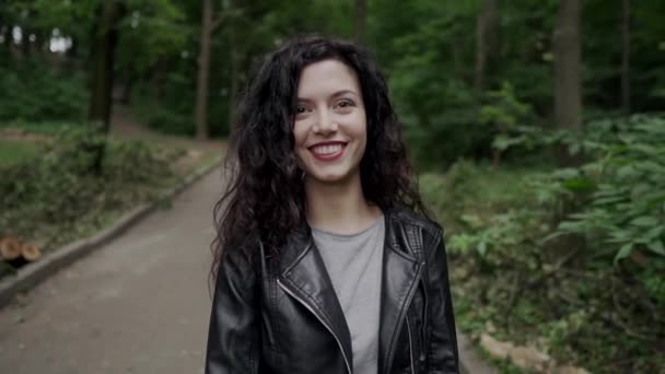 Fiatal gyönyörű göndör barna nő mosolyog és séta — Stock videók