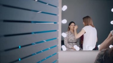 güzel kadın gözlerine gölgeler uygulayan sanatçı makyaj