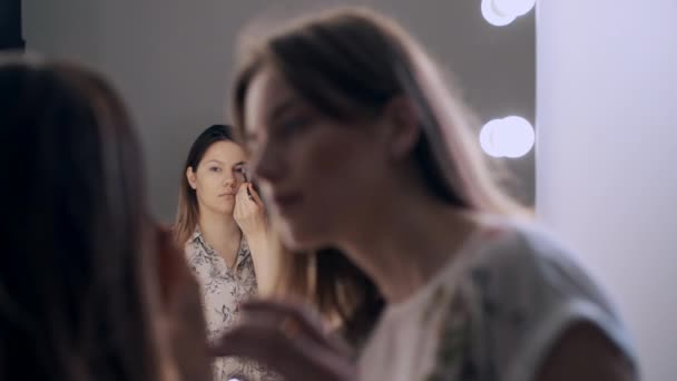 Vytvořit umělce aplikováním stínů na očích nádherné samice — Stock video