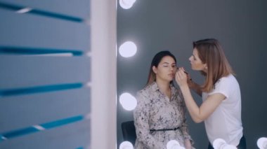 güzel kadın gözlerine gölgeler uygulayan sanatçı makyaj