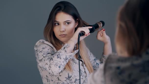 カーリングアイロンでかわいいブルネット女性のストレートヘア — ストック動画