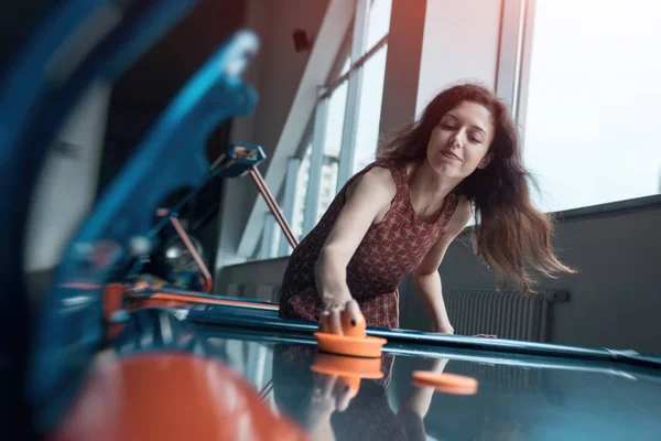 Schöne brünette Frau spielt Airhockey mit Freund — Stockfoto