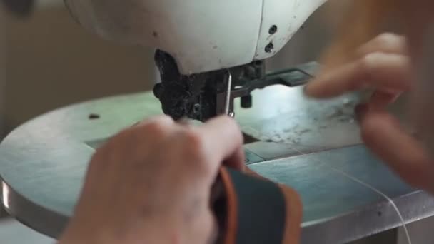 Женщина-работница шьет кожу на обувной фабрике — стоковое видео