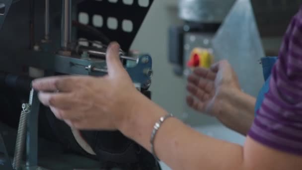 Kobieta pracownik podejmowania buty na obrabiarka w produkcji — Wideo stockowe