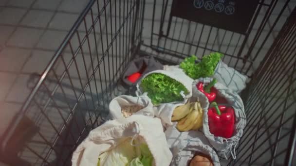 Újrahasznosítható és nulla hulladékú pamutbevásárlószatyrok készlete élelmiszerekhez a kosárban — Stock videók