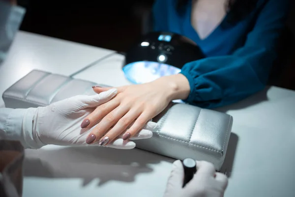 Primer plano de tiro y artista de manicura haciendo limpieza de uñas y pulido — Foto de Stock