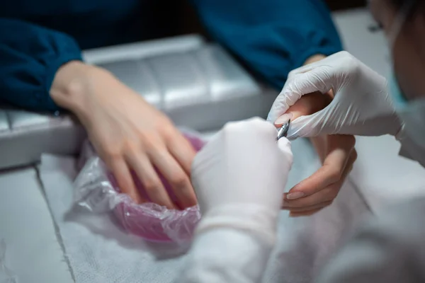 Primer plano de tiro y artista de manicura haciendo limpieza de uñas y pulido — Foto de Stock