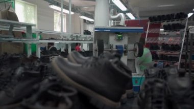 Ayakkabı imalatında, deri ayakkabı rafları olan bir iş yeri.