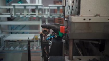 Ayakkabı fabrikasında otomatik makinelerle çalışan bir adam.