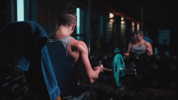 Atlético homem com perfeito torso exercitando com halteres no ginásio — Vídeo de Stock
