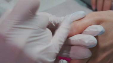 Yakın çekim ve manikür sanatçısı tırnak temizleme ve cilalama yapıyor.