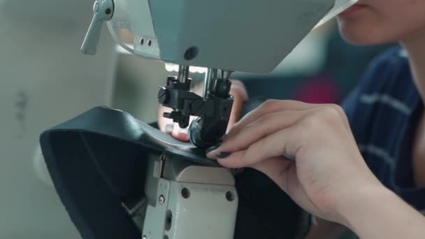 Female worker sews on sewing machine at factory — Stock Video
