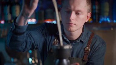 Kahveci likör ve meyve suyuyla egzotik kokteyl hazırlıyor.