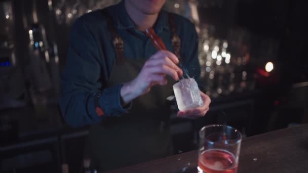 Bartender preparar tradicional coquetel à moda antiga com uísque e laranja — Vídeo de Stock