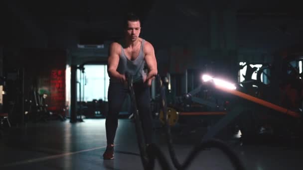 Atrativo atlético fitness masculino exercitando cordas no ginásio moderno — Vídeo de Stock