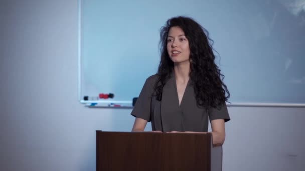 Attrayant bouclé brunette femelle expliquer leçon à l'école — Video