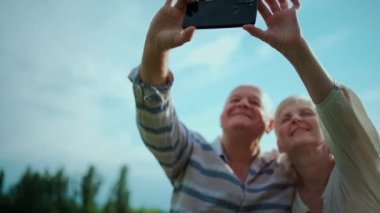 Mutlu yaşlı çiftler çıkıyor, selfie çekiyor ve dışarıda eğleniyorlar.