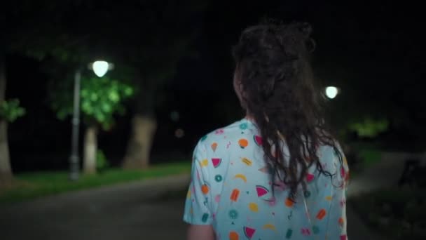 Милый привлекательный подросток брюнетка женщина ходить и танцевать в светлом ночном парке на открытом воздухе — стоковое видео