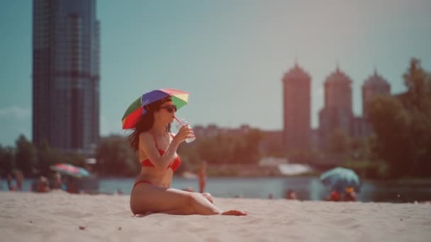 Bellissimo riposo femminile sulla spiaggia della città con ombrellone e bere cocktail mojito — Video Stock