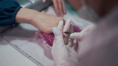 Yakın çekim ve manikür sanatçısı tırnak temizleme ve cilalama yapıyor.