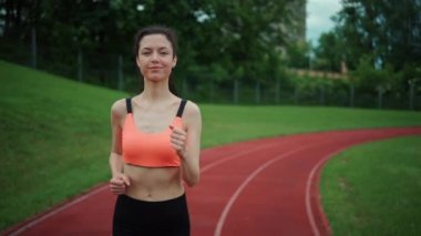 Atletik kadın yazın dışarıda koşuyor ve antrenman yapıyor.