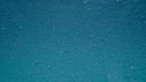 Gotas de agua de lluvia tropical caen en el lago azul claro o piscina — Vídeo de stock