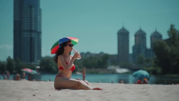 krásná žena odpočinek na městské pláži s deštníkem a pít mojito koktejl