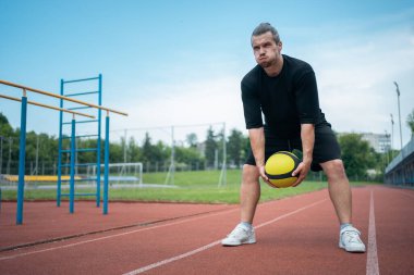 Tıp topu sporcusu ve özel antrenörü dışarıda çalışıyor.