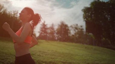 Güneşli yaz sabahında parkta atletik bayan koşucu egzersizi.