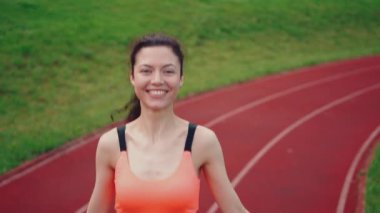 Genç atletik kadın atlıyor ip atlıyor ve yazın stadyumda antrenman yapıyor.