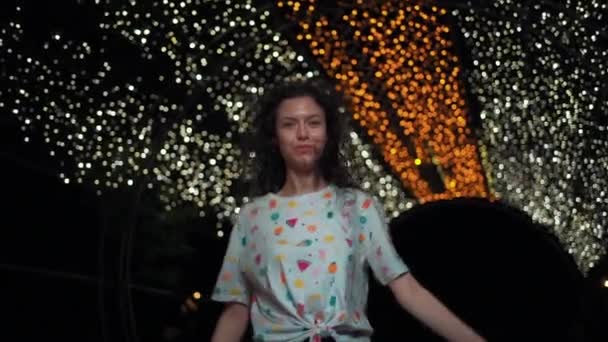 Эмоциональные кудрявые волосы брюнетка леди улыбка и ходьба в городе ночью свет на открытом воздухе — стоковое видео
