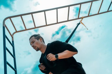 Genç sporcu ya da vücut geliştirici Trx 'le spor yapıyor.