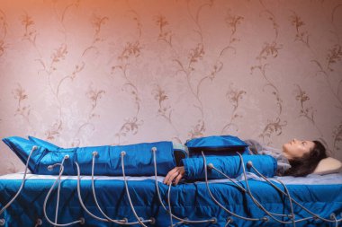 Hasta spa salonunda zayıflatmak için modern pressoterapi makinesi kullanıyor.