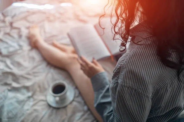 Όμορφη μελαχρινή γυναίκα στο πρωινό κρεβάτι με βιβλία και καφέ — Φωτογραφία Αρχείου
