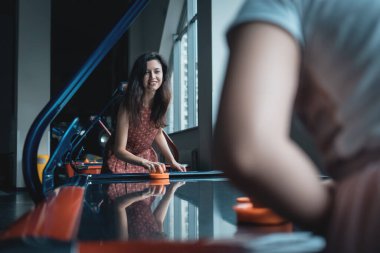 Güzel esmer kadın arkadaşıyla hokey oynuyor.