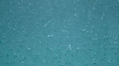 Tropikal yağmur damlaları berrak mavi göle veya havuza düşer