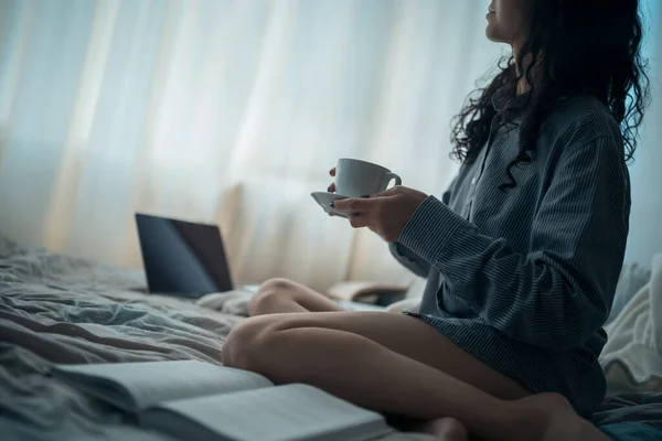 かなりブルネットの女性と朝のベッドで本とコーヒー — ストック写真