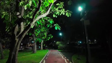 Geceleri aydınlık modern park, temiz tasarım ve dingin güzellik, şehir akşam bahçesinde sakin bir yürüyüş, düzenli bir ortam ve huzurlu bir konfor. Yüksek kalite 4k görüntü