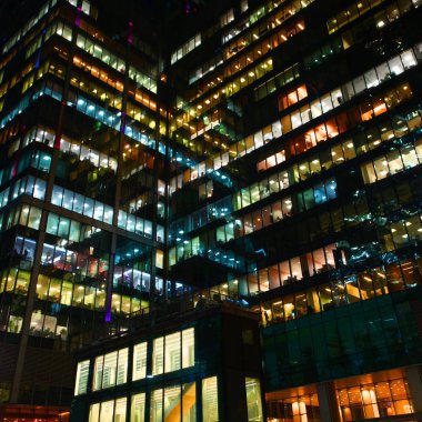 Gece çalışması. Beyaz, mavi, kırmızı ve cam yüzeylerde yansıyan parlak renkli cam ofis windows.