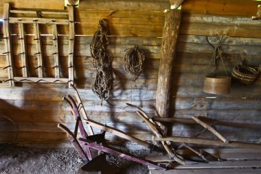 Rus köylü kulübe iç. köylü hisse senedi-pulluk, harrow, ip, ahşap duvar arka plan üzerinde sepet