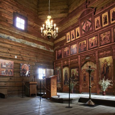 Eski bir ahşap Ortodoks kilise içinin. Rusya, Suzdal. İkonostasisin, Ortodoks simgeler, günlük duvarlar, mumlar. Kırmızı ve sarı renkler doymuş.